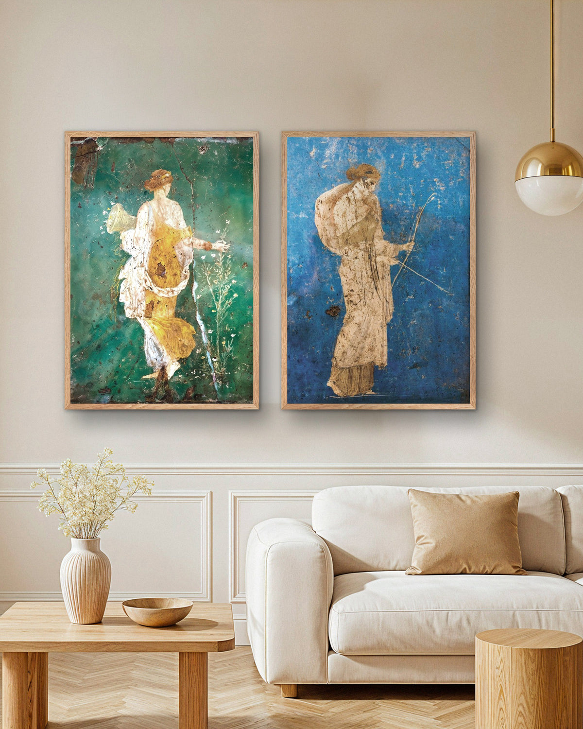 Sett med 2 postere med romerske fresker, Flora og Artemis, i naturfargede trerammer over en sofa i en stue